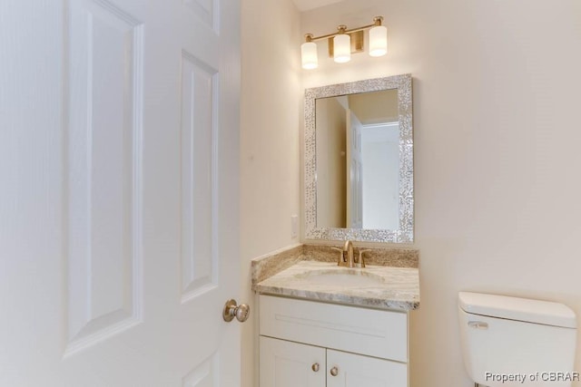 half bathroom featuring vanity and toilet