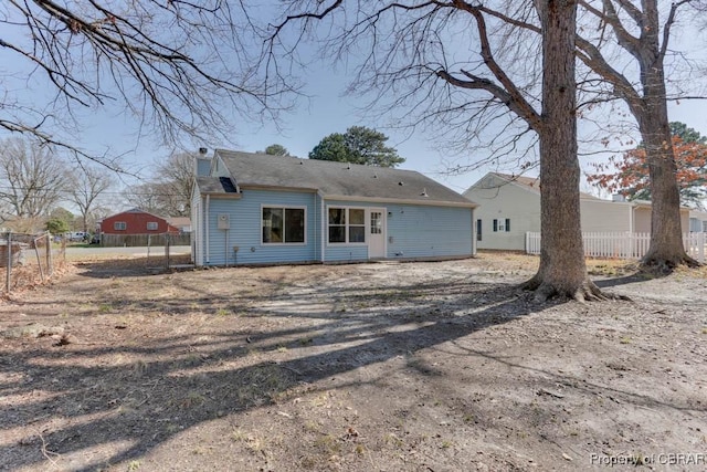 rear view of house featuring fence