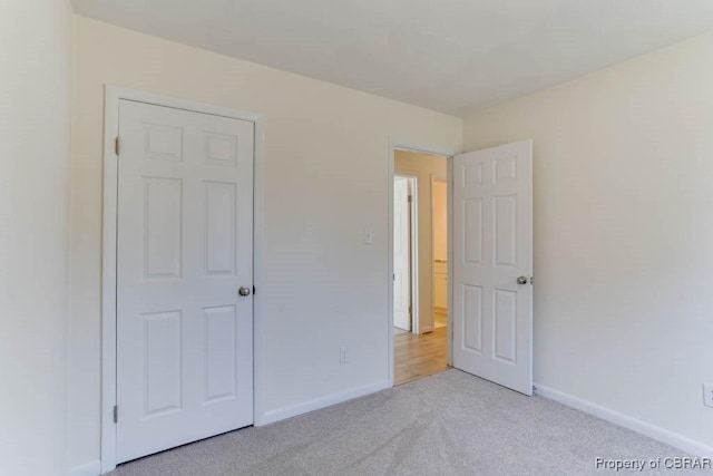 unfurnished bedroom with baseboards and light colored carpet