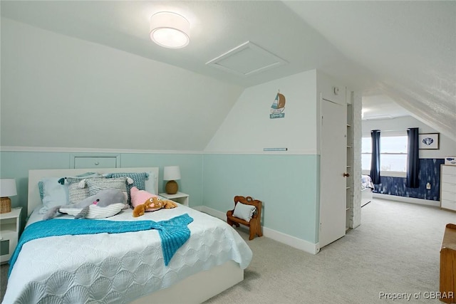 carpeted bedroom with attic access, baseboards, and vaulted ceiling