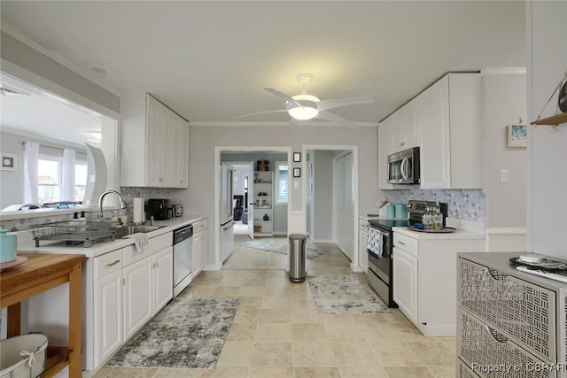 kitchen featuring white cabinetry, stainless steel appliances, light countertops, and a ceiling fan