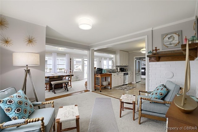 living room with light colored carpet, ornamental molding, and a ceiling fan