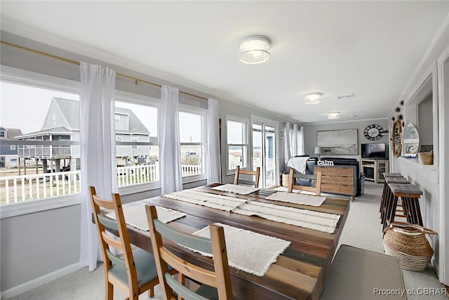 carpeted dining room with baseboards and visible vents