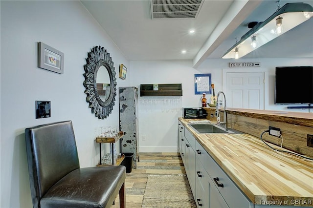 kitchen featuring visible vents, recessed lighting, light wood-style flooring, wood counters, and a sink