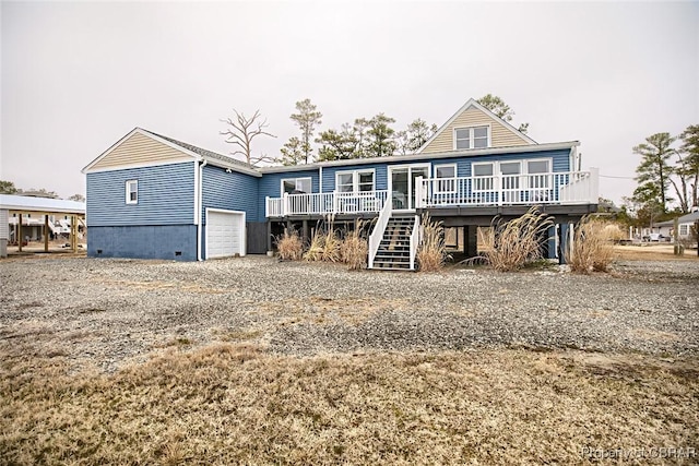 back of property featuring stairway, driveway, and a deck