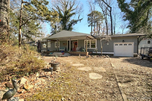 ranch-style home featuring board and batten siding, a porch, a garage, and dirt driveway