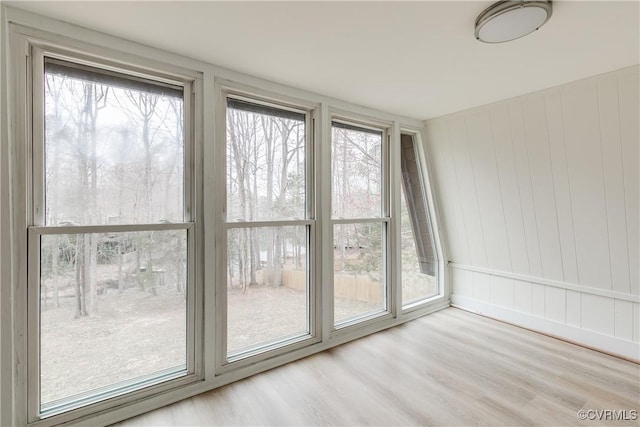 unfurnished room with a wealth of natural light and wood finished floors