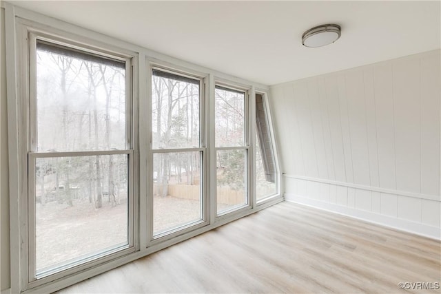 unfurnished room with a wealth of natural light and wood finished floors