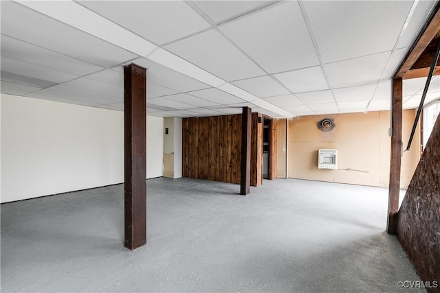 finished basement with heating unit and a paneled ceiling