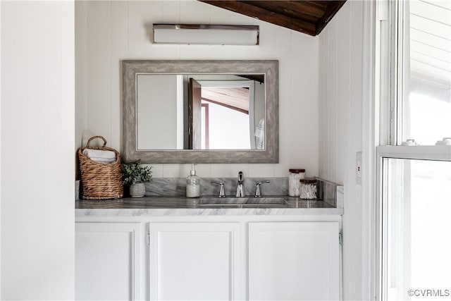 bathroom featuring lofted ceiling and vanity