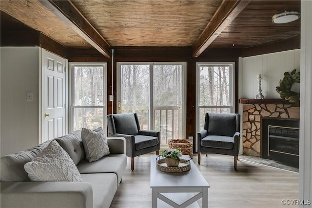 living area featuring beamed ceiling, wooden ceiling, and wood finished floors