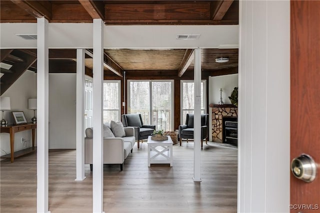 living room with visible vents, beam ceiling, wood ceiling, and wood finished floors