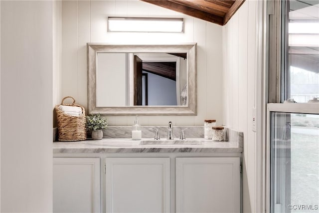 bathroom featuring vanity and lofted ceiling with beams