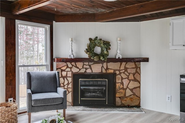 sitting room with a fireplace, wooden ceiling, beamed ceiling, and wood finished floors