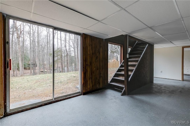 basement featuring a drop ceiling and stairway