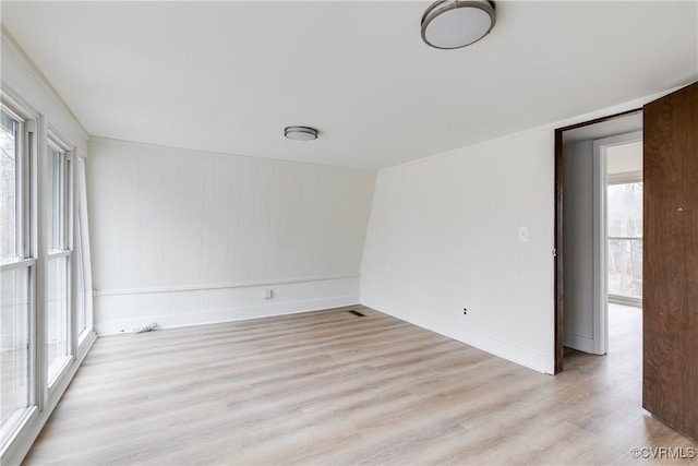 spare room with light wood-type flooring and baseboards