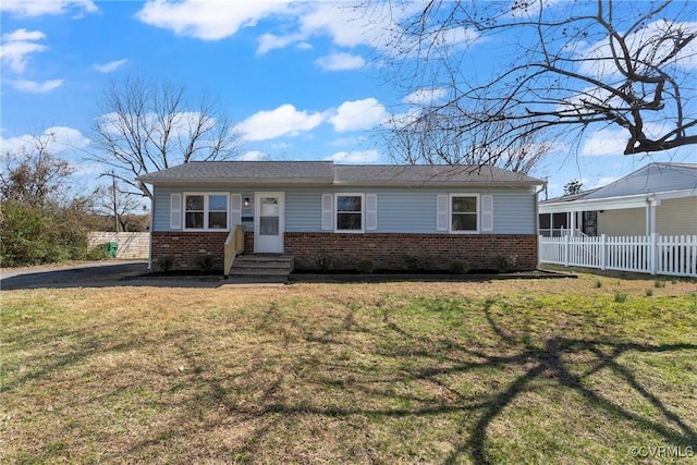 ranch-style home with a front lawn, fence, and brick siding