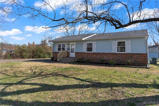 view of front of property featuring brick siding, cooling unit, and a front yard