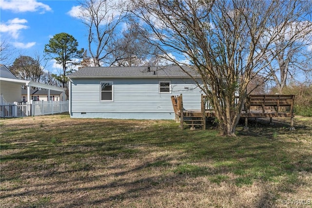 rear view of property with a lawn, a deck, fence, a shingled roof, and crawl space