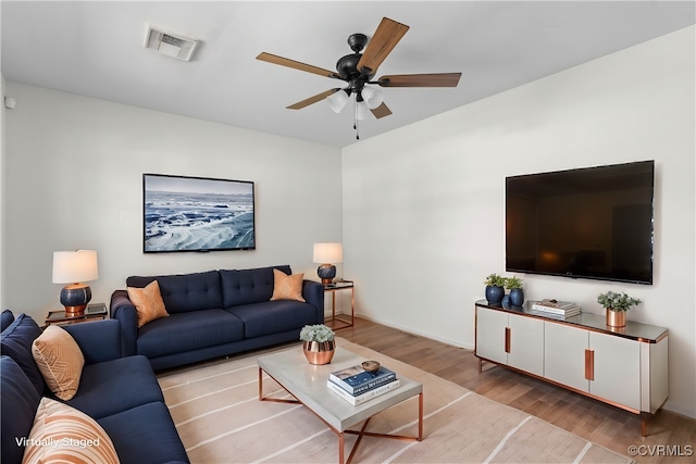 living area featuring visible vents, wood finished floors, and ceiling fan