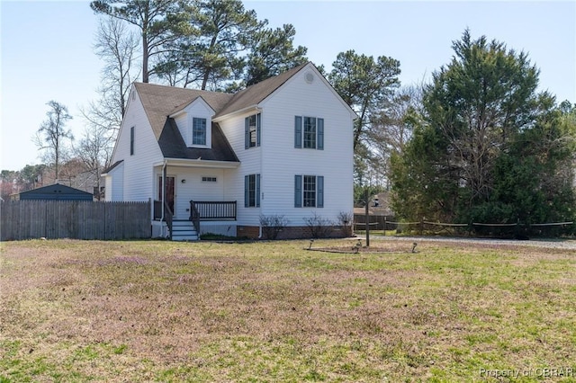 traditional home featuring a front yard and fence