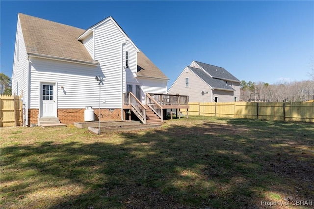 back of property with a wooden deck, a lawn, roof with shingles, and a fenced backyard