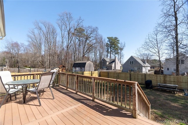 wooden terrace featuring a residential view, a fenced backyard, and outdoor dining space