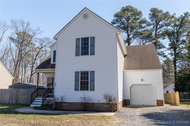 traditional-style house with driveway, a shingled roof, a garage, and fence