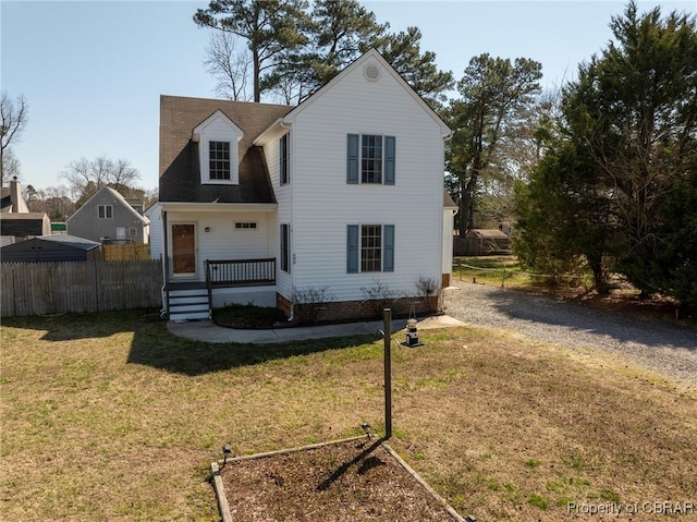 traditional-style home with a front yard and fence