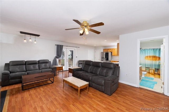 living room with a ceiling fan, baseboards, recessed lighting, light wood-style floors, and french doors