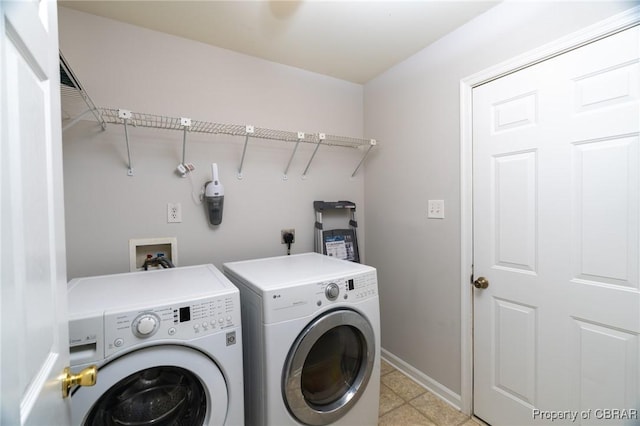 clothes washing area featuring laundry area, baseboards, and independent washer and dryer