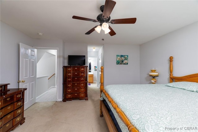 bedroom with connected bathroom, light carpet, and ceiling fan