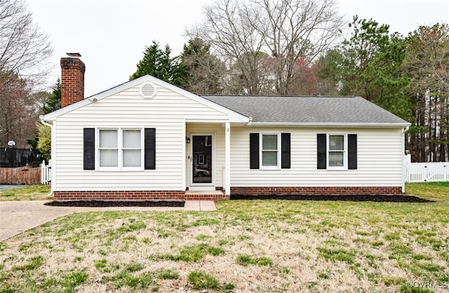 ranch-style home with a shingled roof, a chimney, a front yard, and fence