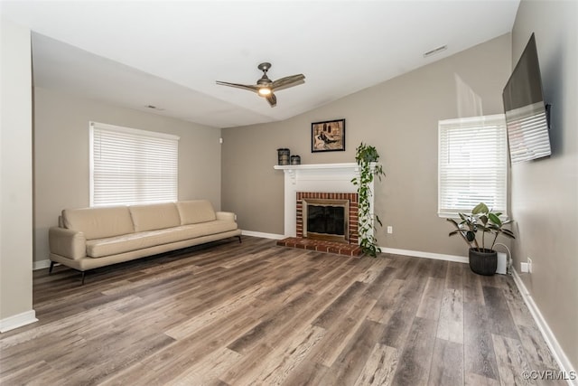 unfurnished living room with wood finished floors, ceiling fan, a fireplace, and vaulted ceiling