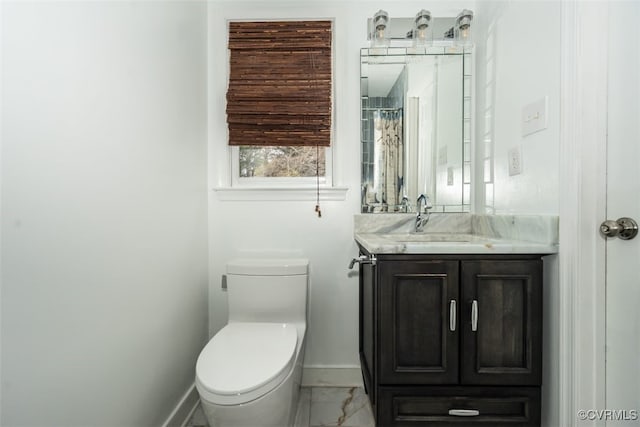 bathroom featuring marble finish floor, toilet, vanity, and baseboards