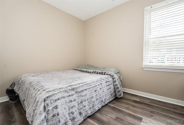 bedroom featuring baseboards and wood finished floors