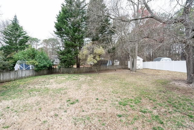 view of yard with an outdoor structure, a storage unit, and a fenced backyard