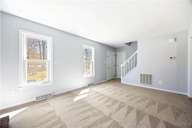 unfurnished living room featuring stairs, carpet, and visible vents