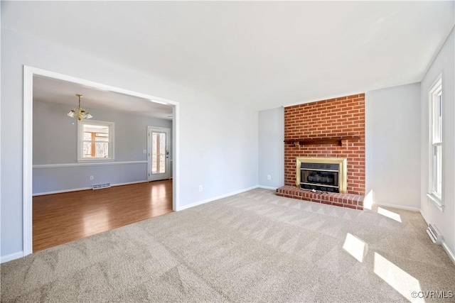 unfurnished living room with visible vents, a brick fireplace, baseboards, and carpet floors