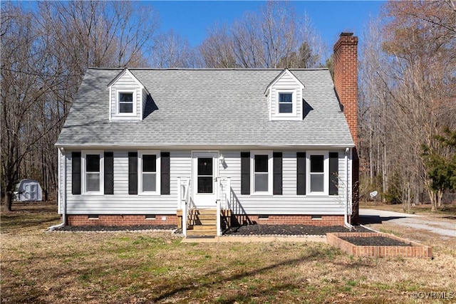 cape cod home featuring a shingled roof, a front yard, entry steps, and crawl space