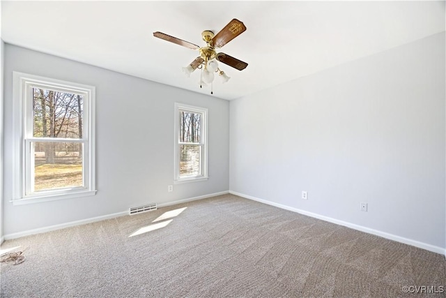 spare room with a ceiling fan, carpet, visible vents, and baseboards