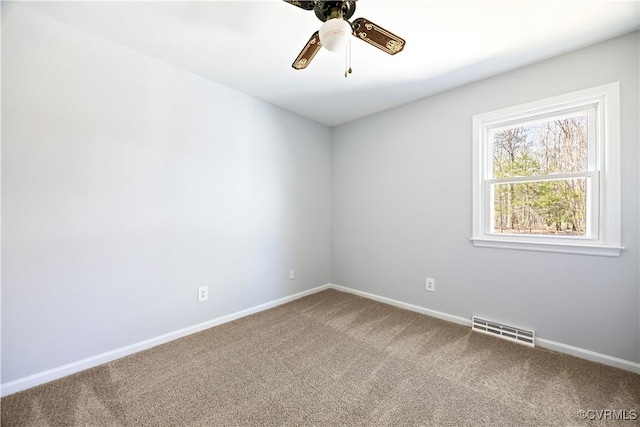 carpeted empty room featuring visible vents, baseboards, and a ceiling fan