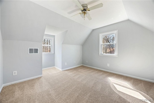 additional living space featuring plenty of natural light, baseboards, visible vents, and light carpet