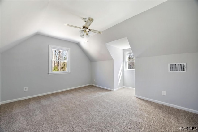 bonus room with vaulted ceiling, light colored carpet, visible vents, and baseboards