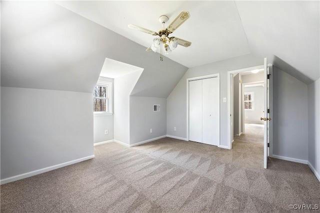 bonus room with a ceiling fan, visible vents, baseboards, carpet floors, and lofted ceiling