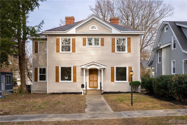 view of front facade with a front lawn and a chimney