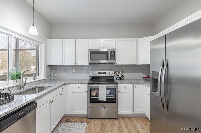 kitchen featuring a sink, stainless steel appliances, tasteful backsplash, and white cabinets