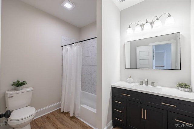 full bathroom featuring toilet, vanity, baseboards, and wood finished floors