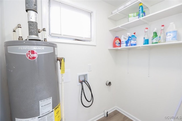 laundry area with baseboards, gas water heater, washer hookup, laundry area, and wood finished floors