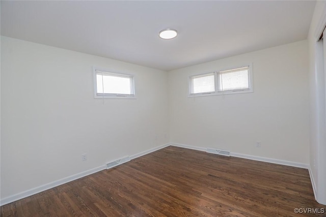 unfurnished room with a healthy amount of sunlight, visible vents, and baseboards